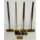 A set of four vintage wooden croquet mallets, along with four croquet balls etc
