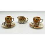 Two Clarice Cliff Bizarre 'Rhodanthe' Lynton cup and saucers along with a milk jug