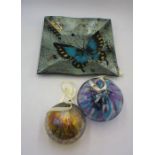 A collection of art glass including two hanging witch's balls and a bowl with butterfly design.