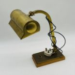 An adjustable brass bankers lamp on wooden base