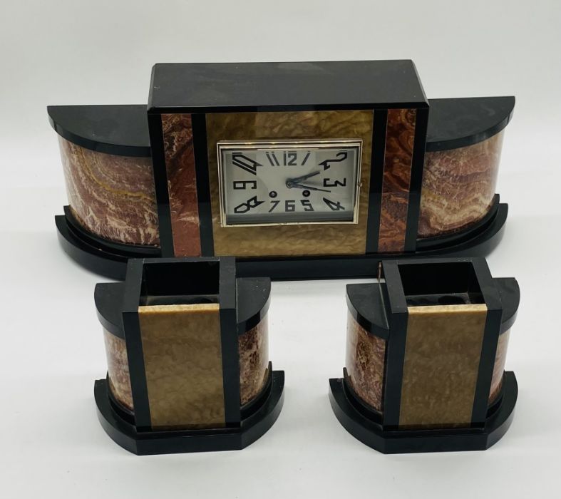 An Art Deco marble clock with garnitures