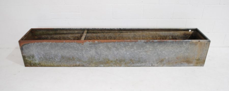 A large galvanised metal animal feeding trough - length 244cm