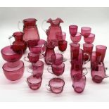 A collection of various cranberry glass including jugs, beakers, glasses bowls etc.