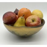 A Naharlya art glass bowl with a collection of imitation fruit