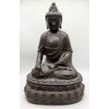 A Chinese 18th century patinated bronze figure of Buddha seated on double lotus throne, his right