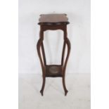 A mahogany plant stand with carved decoration - height 93cm