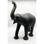 A Liberty style leather elephant with glass eyes and plastic tusks - overall height 85cm x 70cm