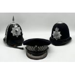 Two Metropolitan Police custodian helmets along with a cap