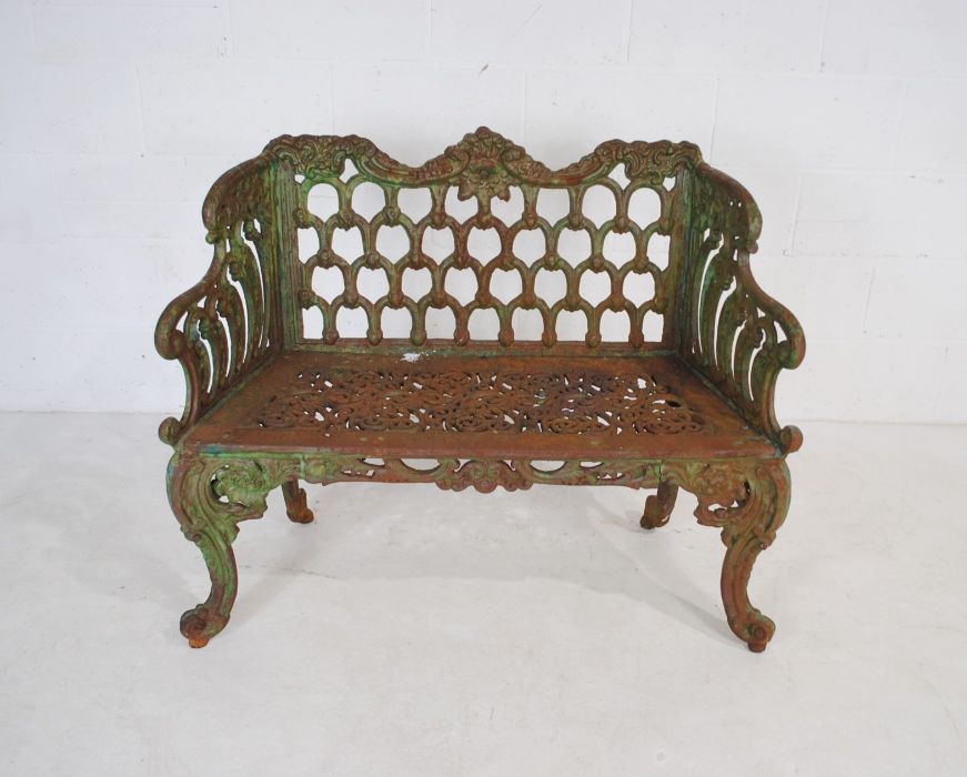 A Victorian weathered cast iron bench with ornate detailing - length 110cm