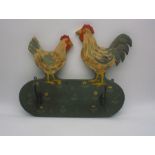 A folk art coat rack with chicken decoration.