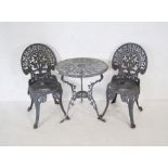 A weathered painted metal garden bistro suite comprising of a circular table and two chairs