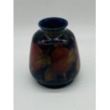 A Moorcroft "Pomegranate" vase of flared barrel form (height 15cm), repair to rim, stamped Moorcroft