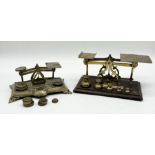 A set of postal scales with weights along with another brass set of scales