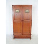 A stained pine wardrobe with single drawer under, raised on rounded feet - length 95cm, depth