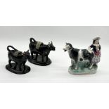 An antique Staffordshire cow creamer with black and white cow and milkmaid (repairs as shown)