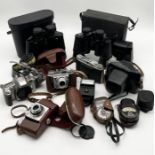 A collection of various vintage cameras and binoculars including Zenit-E, Kodak etc.