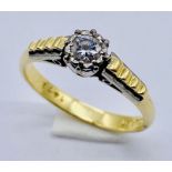 An 18ct gold and platinum ring set with a solitaire diamond