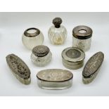 A collection of silver topped dressing table pots along with a silver topped match striker and SCM