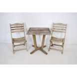 A weathered wooden garden bistro suite consisting of two folding chairs and a table (A/F)