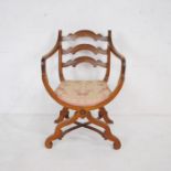 A Spanish style carver chair with cross frame supports