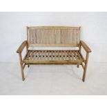 A weathered wooden garden bench with slatted seat - length 120cm