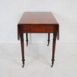 An early Victorian mahogany Pembroke table with single drawer and faux drawer, raised on turned