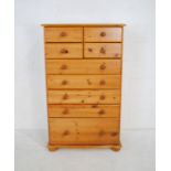 A modern tall pine chest of nine drawers - length 83cm, depth 49cm, height 138cm