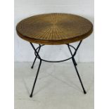 A retro style wicker top circular table with metal legs