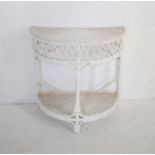 A white painted wicker demi-lune table