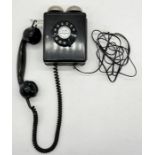 A Weidmann 4259 wall mounted telephone with finger dial and hanging handset