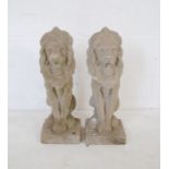 A pair of reconstituted stone garden ornaments in the form of lions - height 56cm