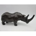 A vintage leather figure of a rhinoceros with glass eyes in the manner of Liberty, length 34cm