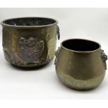 An Arts and Crafts style brass planter/coal bucket with lion's head handles along with another