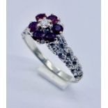 A 9ct white gold ring (tested) set with amethysts and a small diamond, total weight 4.2g