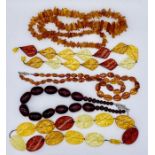 Two amber necklaces along with one other similar and two amber fleck necklaces