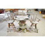 A rustic garden table formed from a tree trunk with a pair of weathered oversized wooden swivel