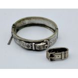 A silver hinged bangle with buckle decoration along with an SCM scarf ring also with buckle
