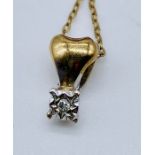 A diamond pendant set in gold on a 9ct gold fine chain