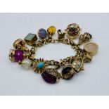 A 9ct gold charm bracelet with a large collection of articulated and other 9ct charms, total