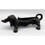 A cast iron boot scraper in the form of a Dachshund