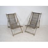 A pair of weathered folding wooden garden chairs with tambour style seats
