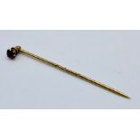 A 15ct gold (tested) stick pin set with a ruby, the top section unscrews