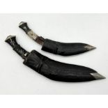 Two vintage Kukri knives with leather scabbards, lions head handle and smaller knives within