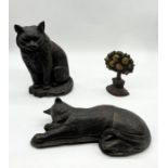 A cast iron doorstop in the form of a cat along with two others