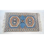 A small blue ground rug with geometric designs - 128cm x 76cm