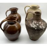 Three large stoneware jugs along with a weathered terracotta jug of conical shape