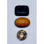 A large amber brooch set on continental silver (800) along with an Acker mourning brooch (pin