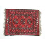 A small red ground Eastern rug - 69cm x 54cm