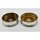 A pair of hallmarked silver bottle coasters