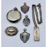 Three hallmarked silver shove ha'penny medallions, silver ingot on chain, Victorian brooch and